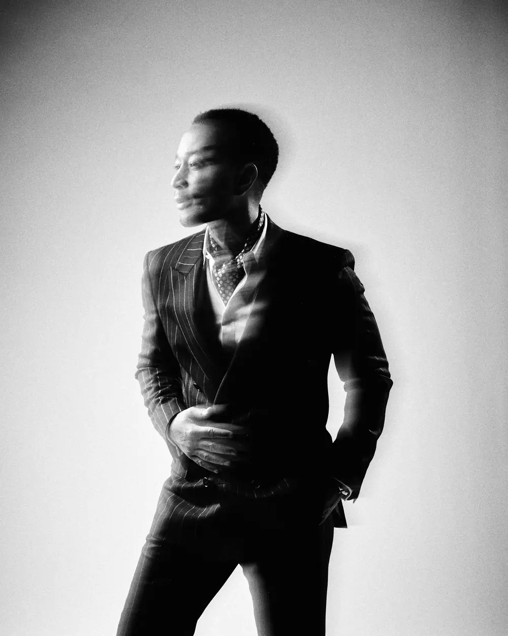 John Legend in a pinstripe suit, softly doubled by a long exposure